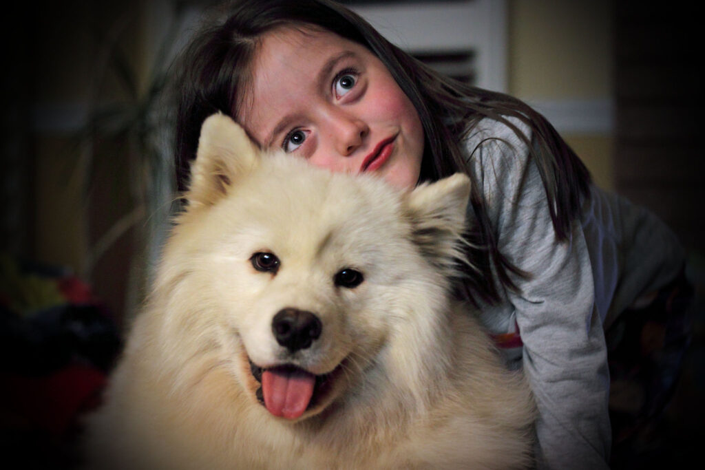 Girl hugs White fluffy dog